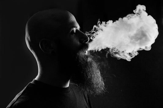 A bald man exhaling vapor