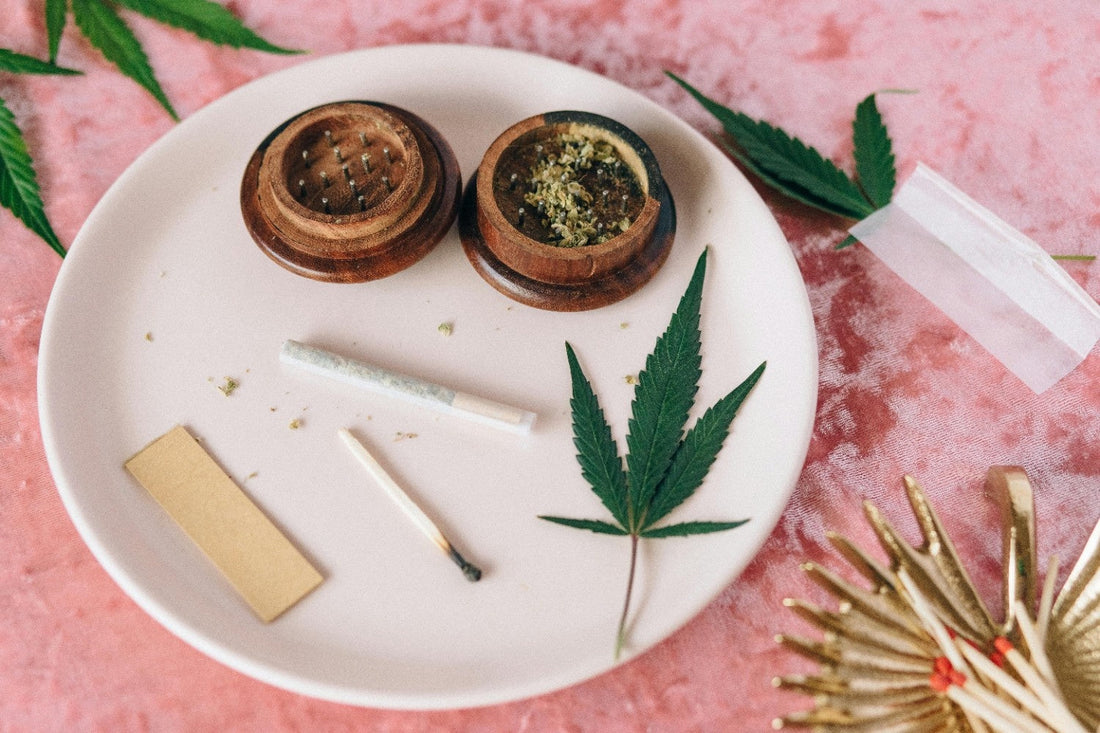 Cannabis grinder with joint on a white plate