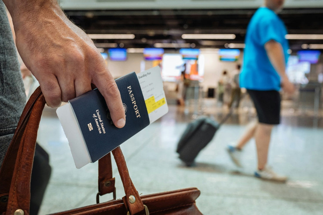 Close-up of a hand with a passport and a carry bag at the airport