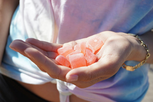 A person’s hand holding red edibles