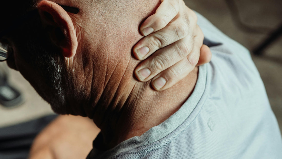 A close-up image of a man rubbing the back of his neck