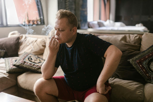 Man smoking weed on a couch