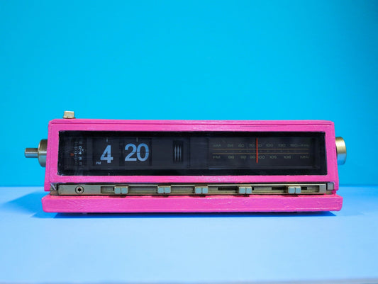 A pink analog clock displaying the time as 4:20 PM