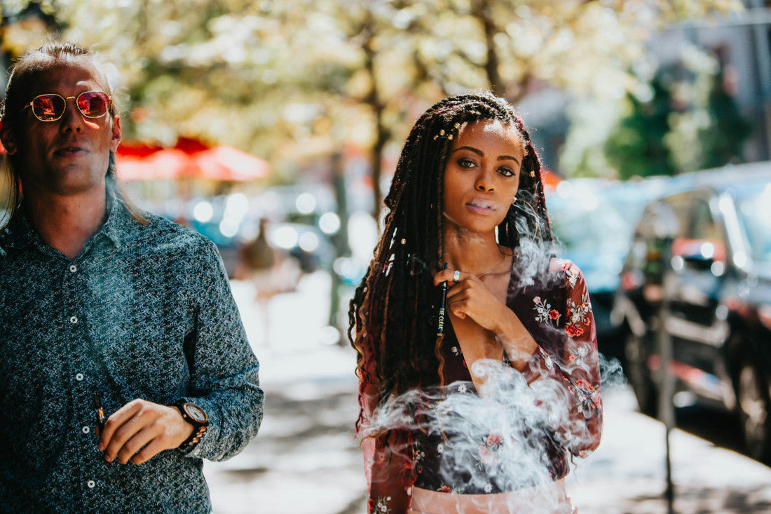 A man and a woman smoking in the street