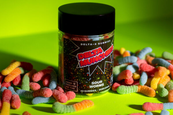 Jar of Delta Munchies' Sour Worms next to sour worm gummies next to it.