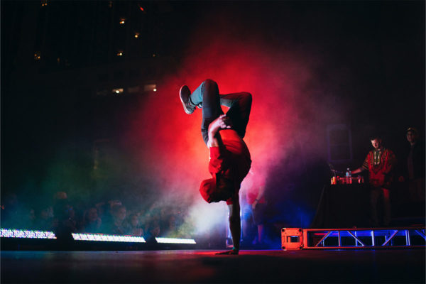 Man in red breakdancing on a stage