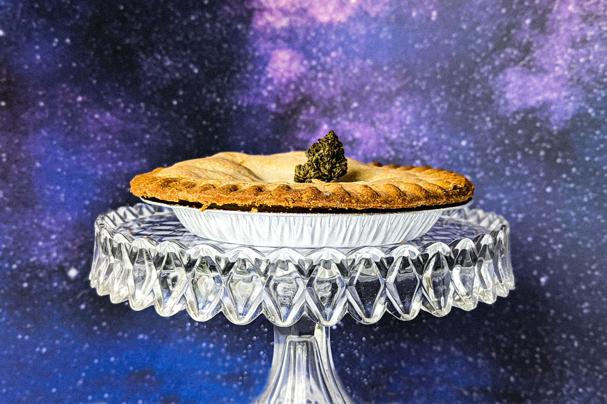 Marijuana bud on a pie on a glass plate on an starry night background.