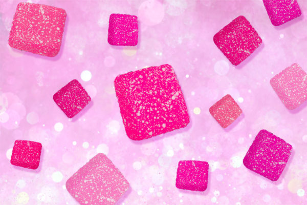 Pink flavored cannabis gummies falling.