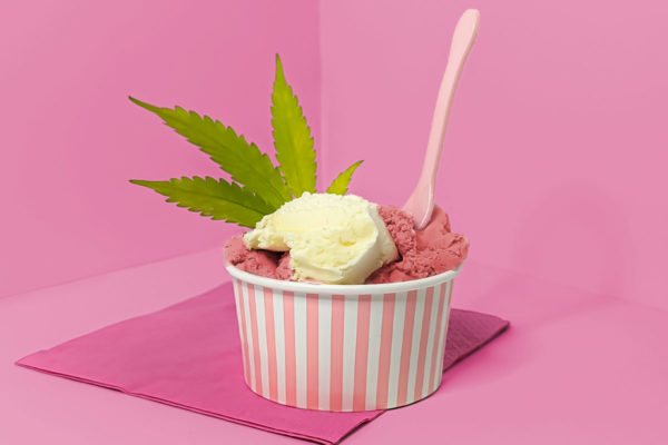 Ice cream jar with strawberry and vanilla flavored ice cream and a marijuana leaf.