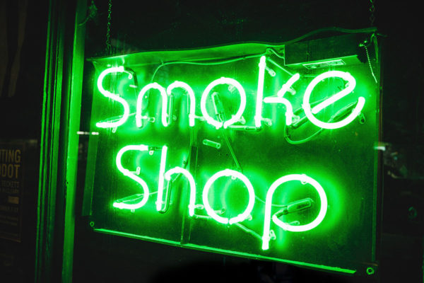 Greeen neon sigh that says "Smoke Shop"