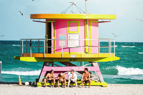 Four men sitting on a lifeguard's station at Miami Beach.