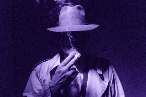 Man in a hat is smoking a cigarette.
