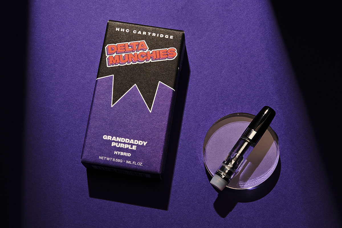 Delta Munchies' Grandaddu Purp HHC vape cartridge on a purple background lit from the top.