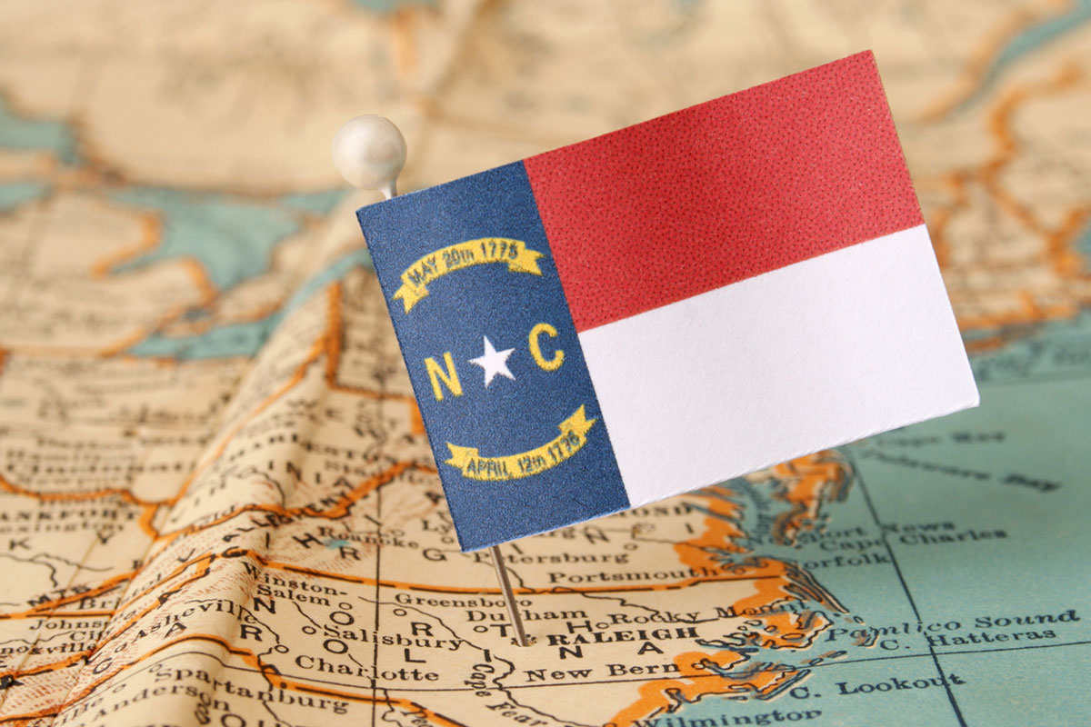 North Carolina flag pinned to a US map.