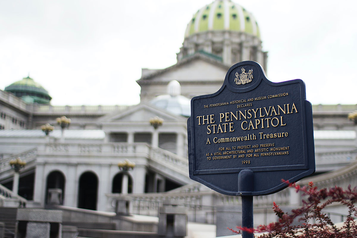 Pennsylvania State Capitol sign with the Capitol behind it.