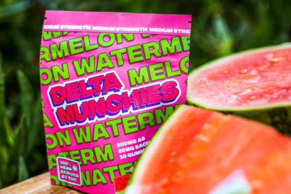 Bag of Delta Munchies Watermelon gummies next to watermelon slices.