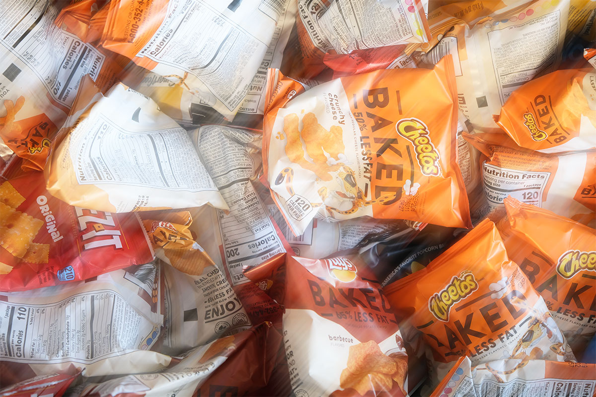 Orange and Red colored packets of Cheetos, Lays, and other snacks with different flavors