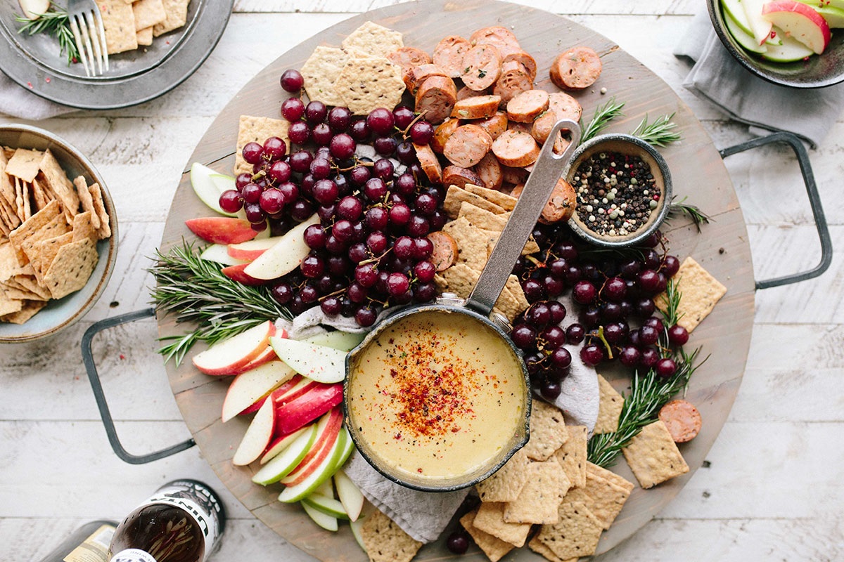 Cheese platter with crackers and sliced fruit.