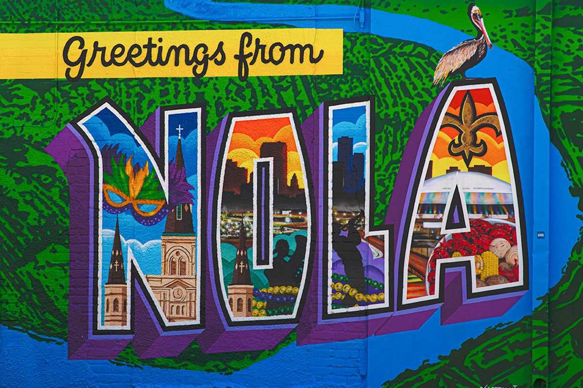 Bold and bright letters spelling 'Greetings from NOLA' stand out in a rainbow of colors against a playful background