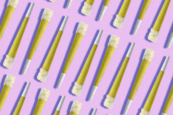 Multiple marijuana joints arranged on a pink background with shadow