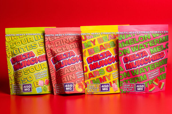 A four-pack of Delta Munchies Delta-8 THC gummies featuring Sour Bites, Peach Rings, Gummy Bears, and Watermelon flavors, on a red surface