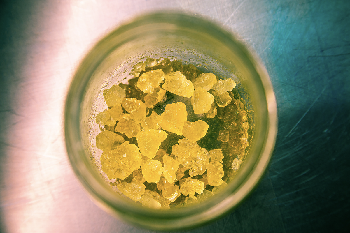 Vibrant yellow rosin carefully placed in a bowl, resting on a sleek black surface